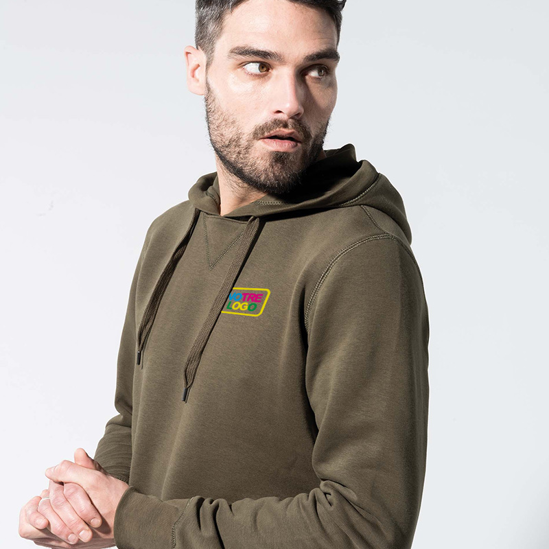 homme avec un sweat à capuche imprimé avec son logo au niveau du coeur