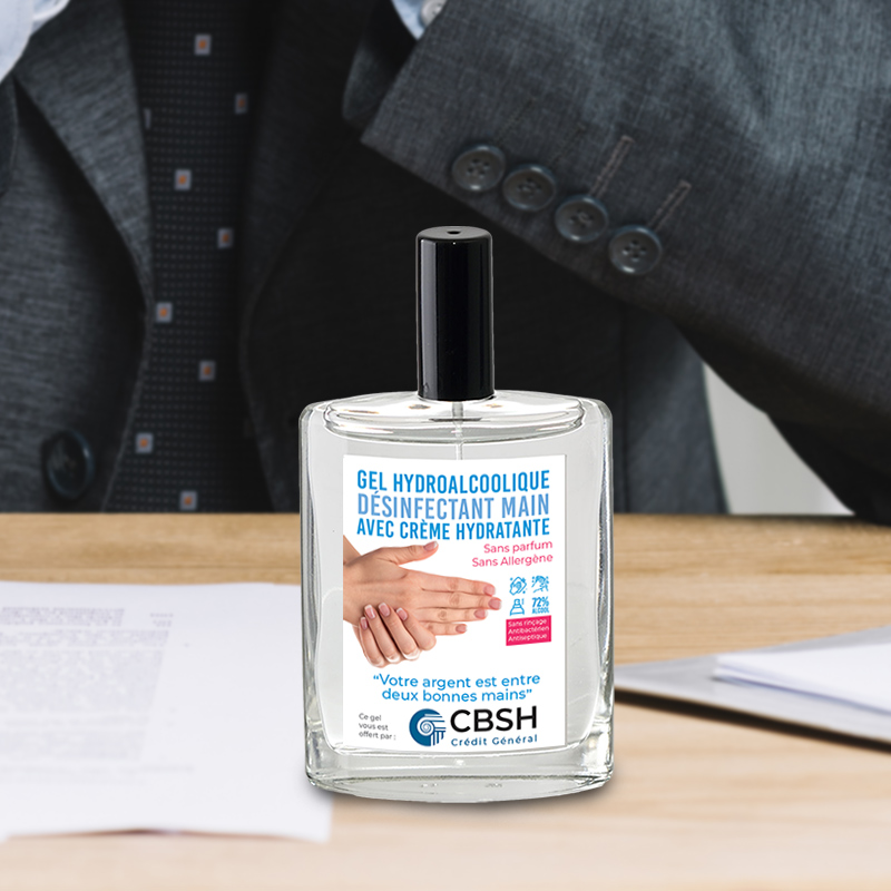 Gel hydroalcoolique publicitaire  en spray avec etiquette personnalisee posé sur un bureau